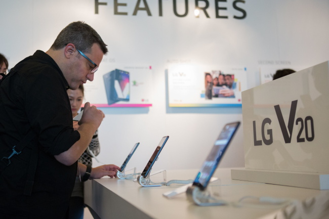 A reporter looks at LG Electronics’ V20 smartphone during a media event held last month in San Francisco. The LG V20 was officially launched in the US and Canada on Friday via local carriers. (LG Electronics)