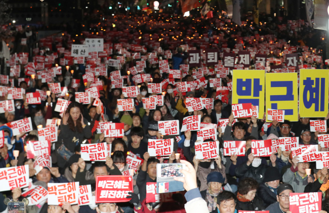 Participants hold a rally Sunday in downtown Seoul demanding President Park Geun-hye step down. (Yonhap)