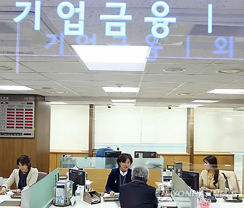 This undated file photo shows bank workers handling corporate financing. (Yonhap)