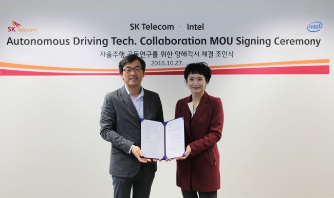 The chief of SK Telecom’s Corporate R&D Center Choi Jin-sung (left) and Intel Korea CEO Kwon Myung-sook sign a memoradum at the SKT headquarters in central Seoul on Oct. 27 (SK Telecom)