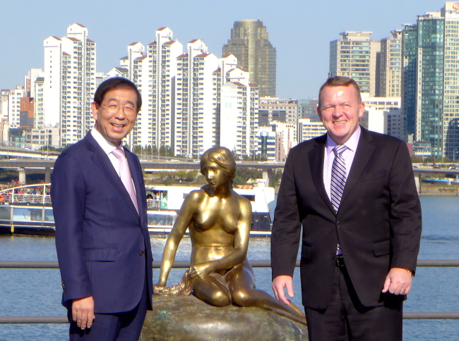Danish Prime Minister Lars Lokke Rasmussen (right) and Seoul Mayor Park Won-soon pose in front of a replica statue of Copenhagen’s “The Little Mermaid” at an unveiling ceremony at Yeouido Hangang Park in Seoul on Oct. 24. (Joel Lee/The Korea Herald)