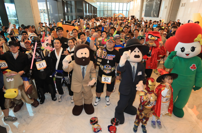 MARATHON FOR LOVE -- Participants cheer before starting the “Challenge for Love 63” marathon held inside the 63 Building in Yeouido, Seoul, Sunday. Hosted by Hanwha Life Insurance, the marathon involves running up 1,251 flights of stairs to the top of the building. By taking part in the marathon, participants donate tickets to diverse attractions inside the 63 Building to underprivileged children. (Yonhap)