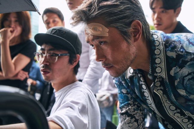 A photo depicts Lee Byung-hun monitoring his performance on the set of the upcoming film “Master.” (CJ Entertainment)