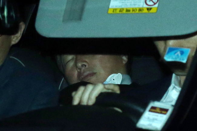 SK Group Chairman Chey Tae-won, with his eyes closed, sits in the backseat of his vehicle leaving the prosecution‘s office on Monday. (Yonhap)