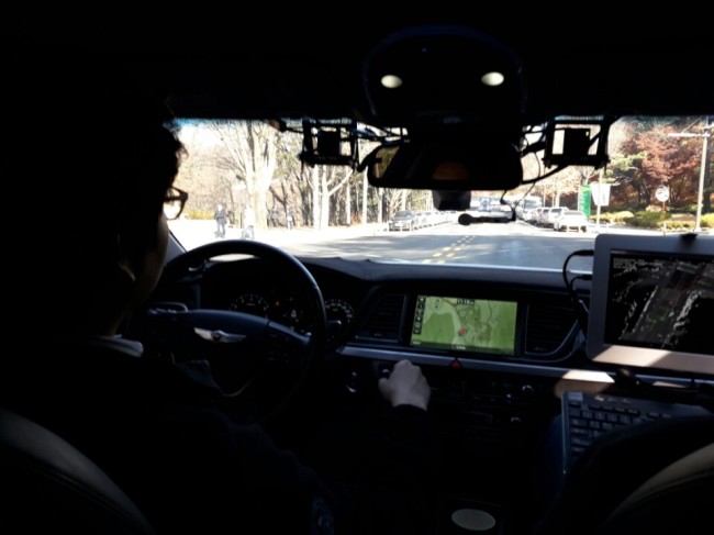 SNU students sit behind the wheel of self-driving car Snuber 2. (Shin Ji-hye / The Korea Herald)