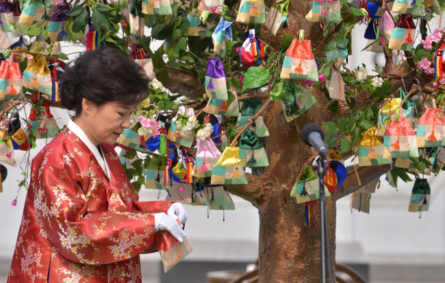 President Park Geun-hye pulls an obangnang open at an event at Gwanghwamun Plaza on Feb. 25, 2013. (The Korea Herald file photo)