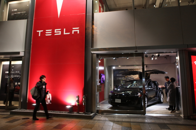 A man walks past Tesla`s Tokyo showroom on Nov. 11 Park Ga-young/The Korea Herald