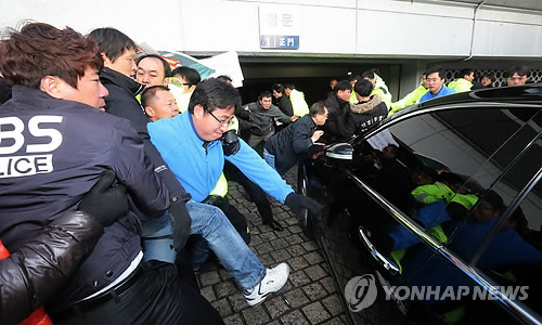 Unionized workers scuffle with security guards at the headquarters of South Korean broadcaster KBS in Seoul on Nov. 26, 2012, as they attempt to block a car carrying the network's then newly-appointed chief Gil Hwan-young from entering the headquarters. (Yonhap)