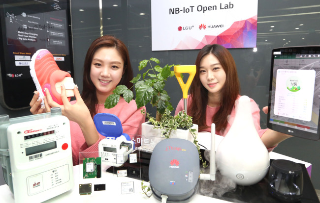 Models hold up NB-IoT chipsets, modules and devices at the newly opened “NB-Iot Open Lab” established by LG Uplus and Huawei on Monday. (LG Uplus)