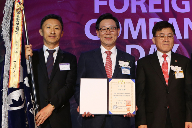 Shinhan Bank‘s Vice President Choi Byung-hwa (center) poses for a photo with Vice Minister Chung Man-ki (right) of the Ministry of Trade, Industry and Energy at 2016 Foreign Company Day in Seoul, Tuesday. (Shinhan Bank)