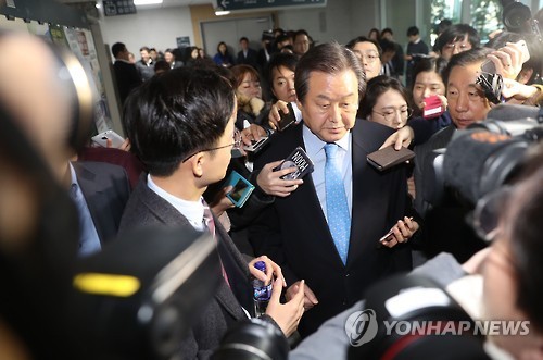 Kim Moo-sung, former head of the ruling Saenuri Party, is surrounded by reporters at the National Assembly on Nov. 23, after a news conference. (Yonhap)