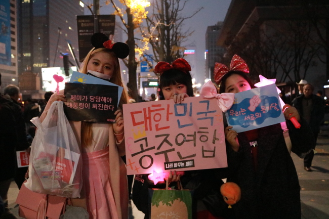 High school students hold a placard reading “Association of Korean Princesses“ during an anti-government rally in central Seoul on Saturday. (Son Ji-hyoung/The Korea Herald)