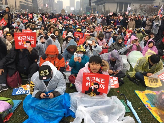 Participants sit in front of the makeshift stage at Gwanghwamun Square in central Seoul ahead of the main event to begin in the evening during anti-Park Geun-hye rally, Saturday. (Ock Hyun-ju/The Korea Herald)