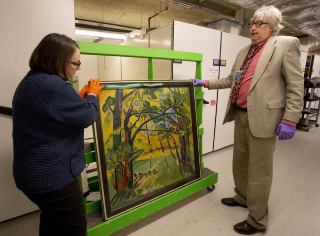 Karen Papineau, left, and Kurt Sundstrom look at the other side of a painting by German artist Max Pechstein, in Manchester, N.H. (AP-Yonhap)