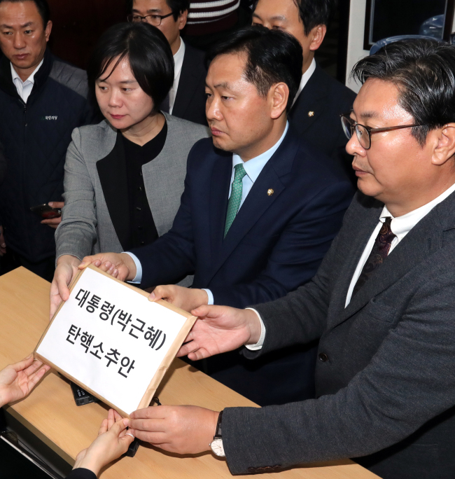 Representatives of three opposition parties hand in the impeachment motion against President Park Geun-hye to the National Assembly secretariat on Saturday. The bill has been signed by the parties’ 171 lawmakers. From right: Reps. Lee Choon-suak of the Democratic Party of Korea, Kim Kwan-young of People’s Party and Lee Jung-mi from Justice Party. (Yonhap)