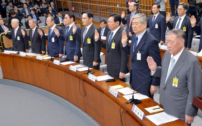 Tycoons take an oath before the parliamentary hearing on Tuesday. (Yonhap)