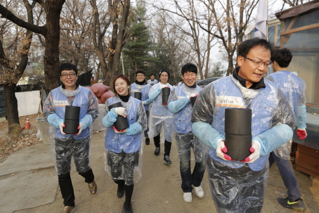 KT&G CEO Baek Bok-in (right) delivers briquettes to poor households in Gaepo-dong in Gangnam, Seoul, Wednesday. (KT&G)