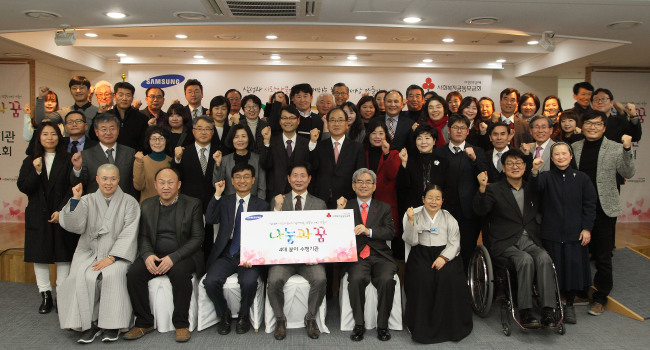 Hwang Chang-soon (third from left, front row), professor at Soonchunhyang University, Yoon Ju-hwa (fourth from left), president of Samsung Corporate Citizenship, and Park Chan-bong (fifth from left), secretary-general of Community Chest of Korea, pose with recipients of Samsung’s “Sharing and Dream” project Wednesday in Seoul. (Samsung Group)