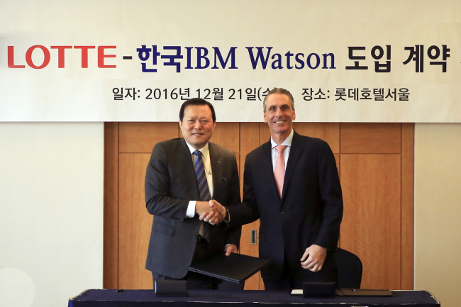 President of Policy Coordination at Lotte Hwang Gak-kyu (left) and IBM’s General Manager of Cognitive Solutions Jay Bellissimo sign a partnership over Lotte’s adoption of IBM’s artificial intelligent solution Watson in Seoul, Wednesday. (Lotte Group)