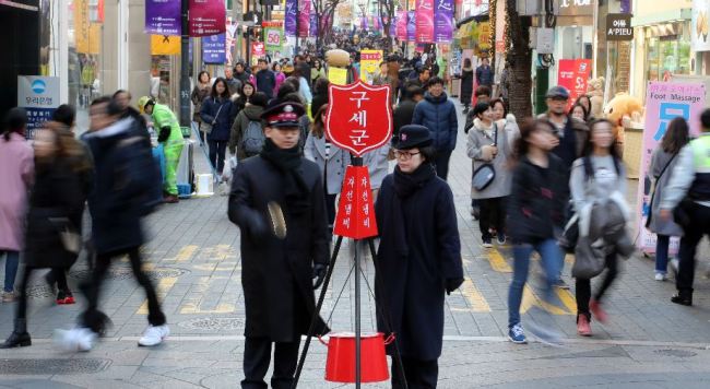 Salvation Army volunteers appeal for donations at a kettle installed in Myeong-dong, a shopping and fashion district in Seoul. (Yonhap)