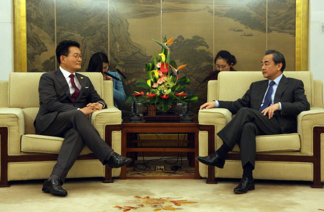 Chinese Foreign Minister Wang Yi (right) and Rep. Song Young-gil of the Democratic Party of Korea (Yonhap)