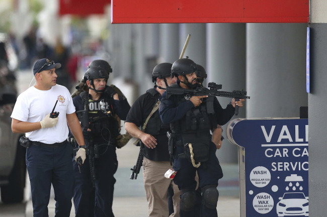 Law enforcement officers walk around Fort Lauderdale-Hollywood International Airport, Friday. (AP-Yonhap)