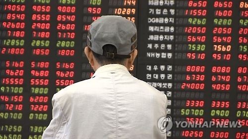 This undated photo shows an investor watching an electronic bulletin board at a brokerage house in Seoul. (Yonhap)