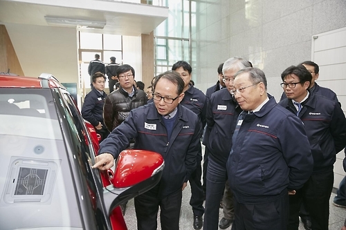 Ssangyong Motor President Choi Jong-sik (2nd from R) examines the company's new touch screen window technology at a company workshop held Feb. 3, 2017, in Anseong, South Korea. (Ssangyong Motor)