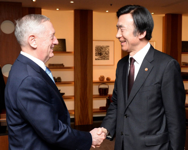 Foreign minister Yun Byung-se (right) shakes hands with US defense secretary James Mattis (Yonhap)