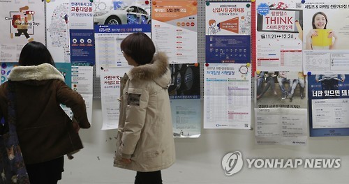 This photo taken on Dec. 14, 2016, shows students at a college in Seoul looking at job ads posted on a school bulletin board. (Yonhap)