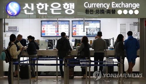 Travelers exchange currencies at Incheon International Airport in this undated file photo. (Yonhap)