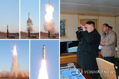 In this photo taken on Feb. 12, 2017, North Korean leader Kim Jong-un (R) observes the test-firing of a Pukguksong-2 missile through binoculars. (For Use Only in the Republic of Korea. No Redistribution) (Yonhap)