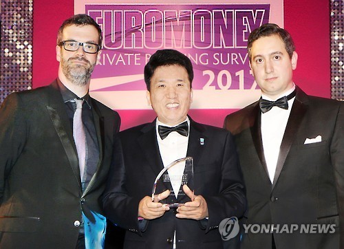 KEB Hana Bank CEO Ham Young-joo (center) poses after receiving the best private bank in Korea award Tuesday. (KEB Hana Bank)