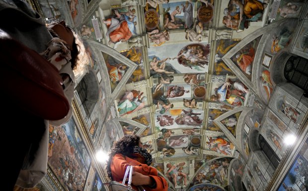 Journalists look at the Sistine Chapel with its new lighting during a press visit to the Vatican, Oct. 29, 2014. (AFP)