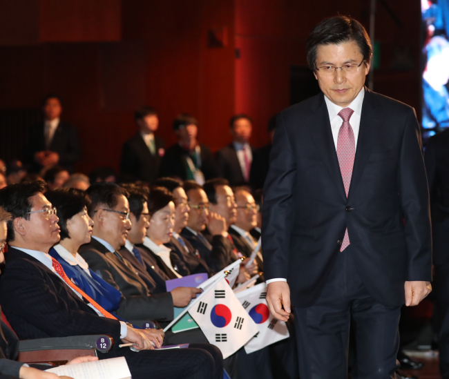 Acting President and Prime Minister Hwang Kyo-ahn walks past the leaders of rival political parties, after delivering his address at the Independence Movement Day ceremony held at Sejong Center for the Performing Arts on Wednesday. (Yonhap)