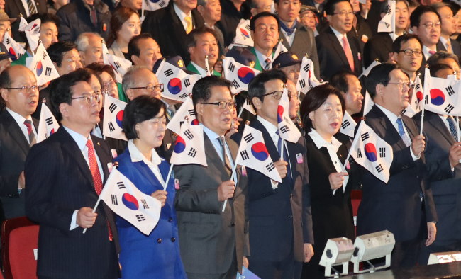 Lawmakers from both conservative and liberal parties wave Korean flag in a ceremony celebrating the nation's Independence Movement Day at Sejong Center in Gwanghwamun, in central Seoul on Wednesday.(Yonhap)