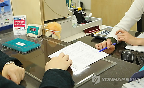 A bank worker taking care of a customer. (Yonhap)