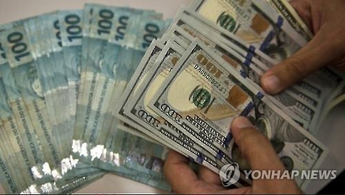 Hands holding bank notes (Yonhap)