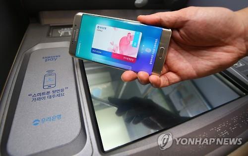 A user demonstrates Samsung Electronics Co.'s Samsung Pay service that works on automated teller machines. (Yonhap file photo)