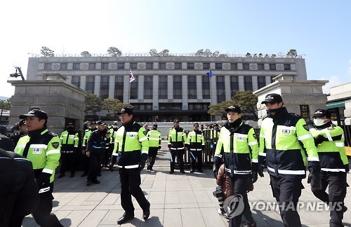 Police officers stand guard at the Constitutional Court in Seoul on March 9, 2017, as protests intensify ahead of the court's upcoming ruling on the impeachment of President Park Geun-hye that will be delivered the next day. People both for and against the impeachment have been rallying around the court, some threatening to harm the judges. (Yonhap)