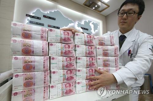 A Seoul bank employee handles Chinese currency (Yonhap file photo)