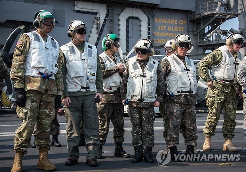 USFK Commander Vincent K. Brooks (far left) and Seoul's JCS Chairman Gen. Lee Sun-jin (4th from left) are briefed on ongoing joint military drills on the USS Carl Vinson aircraft carrier. (Yonhap)