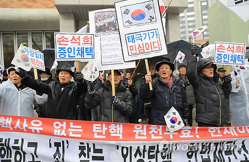 Members of a pro-government civic group suspected of having held demonstrations following the presidential office Cheong Wa Dae's order hold pickets during a protest against impeachment of President Park Geun-hye near the Constitutional Court. The court ruled to permanently remove Park from office on March 10. (Yonhap)