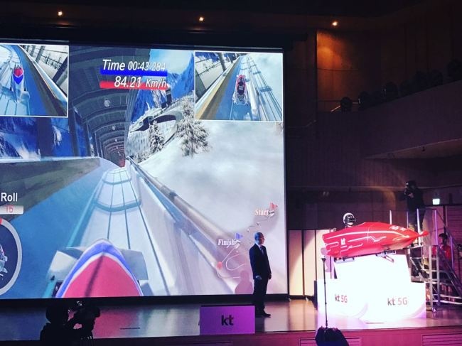 KT’s Network Group President Oh Seong-mok (left) demonstrates a virtual reality experience of an Olympic torch relay during a press conference in PyeongChang on Tuesday. (KT)