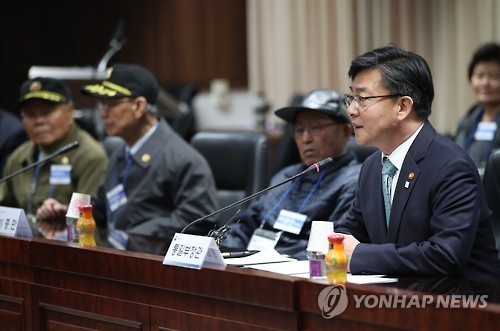 Unification Minister Hong Yong-pyo (L) meets with former South Korean soldiers who were taken prisoner by North Korea during the 1950-53 Korean War and later returned home, at the Unification Ministry on March 15, 2017. (Yonhap)