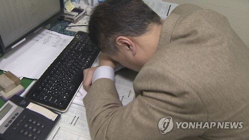 This photo, provided by Yonhap News TV, shows an office worker taking a nap at his office. (Yonhap)