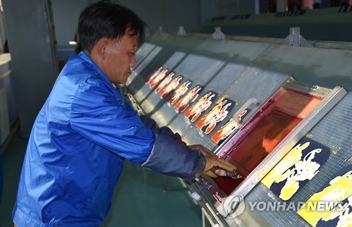 This undated file photo shows a North Korean man working at a bag factory in Pyongyang. (Yonhap)