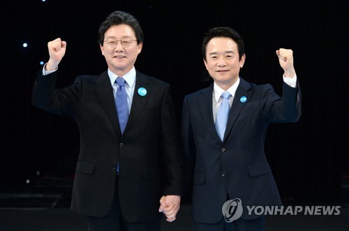 Rep. Yoo Seong-min (L) and Gyeonggi Province Gov. Nam Kyung-pil pose for a photo ahead of their TV debate at KBS broadcasting station in Seoul on March 20, 2017. (Yonhap)