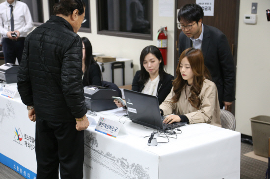 The Korean Consulate General in Los Angeles identifies a voter before giving him a ballot sheet for the April general election last year. (Yonhap file photo)