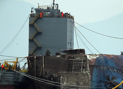 Part of the rusted Sewol ferry resurfaces above the sea off the southwestern island Jindo on March 24, 2017, three years after it capsized and killed over 300 people, with nine still missing. (Yonhap)